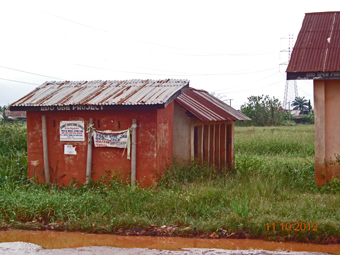 School latrine overtaken by weeds and flood water.